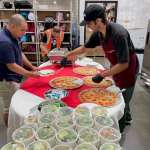 Staff being served lunch at a Pizzarageous catered event